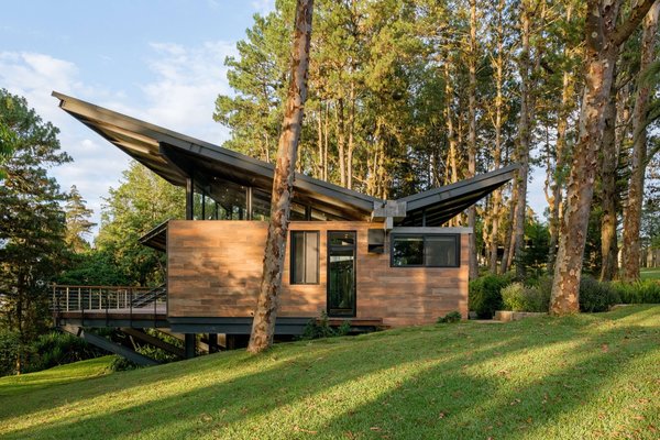 A modest, gabled 1965 hut on the outskirts of Guatemala City was transformed into an expansive 4,467-square-foot getaway. Blurring the indoors and out, architect Alejandro Paz adhered to the original architectural elements while adding modernized touches. The roof maintains the same angle as the original hut, but reversed, while new modules give the space a new identity. With floor-to-ceiling glazing, the home allows for the residents to take in the Guatemalan forest from all angles.