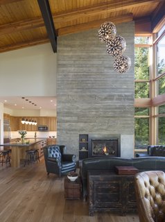 The net-zero home's main living area is anchored by a massive board-formed concrete chimney that, along with the sections of concrete flooring, serve as a thermal heat sink to maintain comfortable indoor temperatures year round.