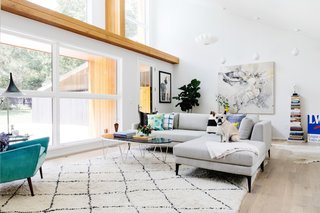 Formerly the garage, the new living room feels bright and spacious thanks to large windows, white walls, and a vaulted ceiling.