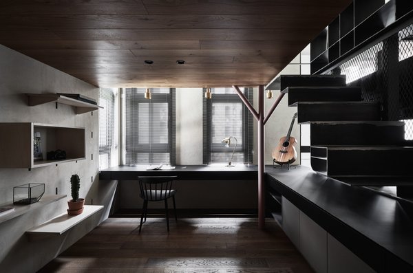 The sunken workspace enjoys access to ample natural light and is flanked by three windows. 