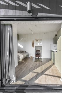 The view of the interior from the terrace. The floors are waterproof laminate and the walls are painted wood siding.