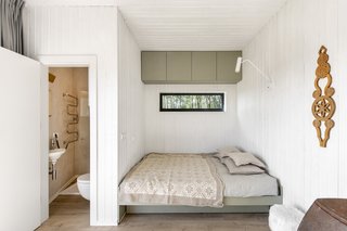 The queen-size bed with natural fiber bedding is perfectly slotted into a corner of the house. The bathroom is fitted with a Gustavsberg basin and tap, as well as a Roca toilet.