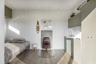 At the heart of the hut is a wood-burning stove. The kitchenette features a Hansgrohe tap, a Franke sink, laminated chipboard cabinets, along with high-pressure laminate counters and backsplashes.