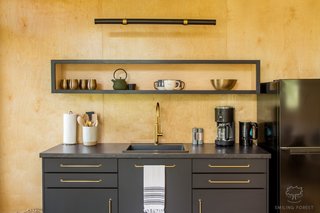 The kitchenette features an IKEA SÄLJAN laminate countertop and SEKTION cabinets. The space also comes with a coffee maker, tea kettle, small induction stove, and refrigerator.