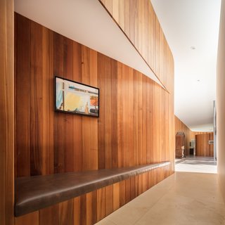 Curved to avoid the dripline of an existing tree, the sinuous wall created an opportunity for in-built bench seating indoors.