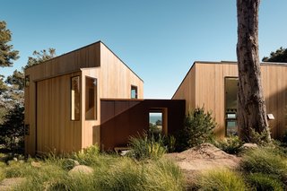 Corrugated Cor-Ten steel clads the entryway that connects the two cedar-clad wings.