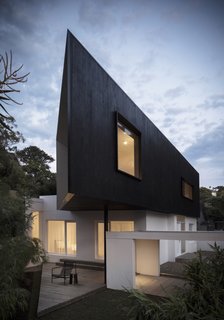 The extension's dark cypress cladding was charred on-site by hand.