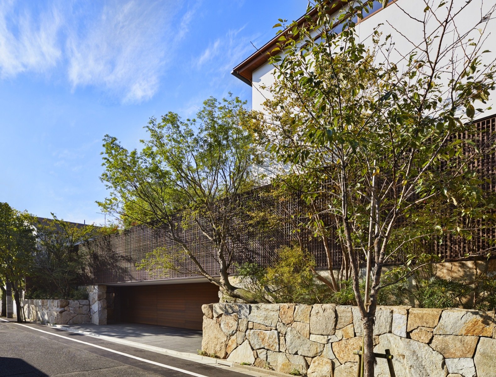A ramp beneath the metal fence leads to a two-car garage hidden under the inner courtyard's grassy knoll.