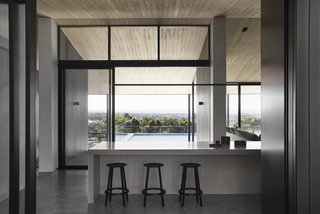 Walls of glass frame views of the lush valley from the kitchen.