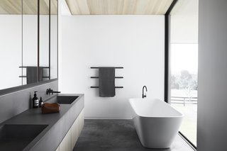 The minimalist approach is carried throughout the home, from the material palette to the streamlined fixtures.