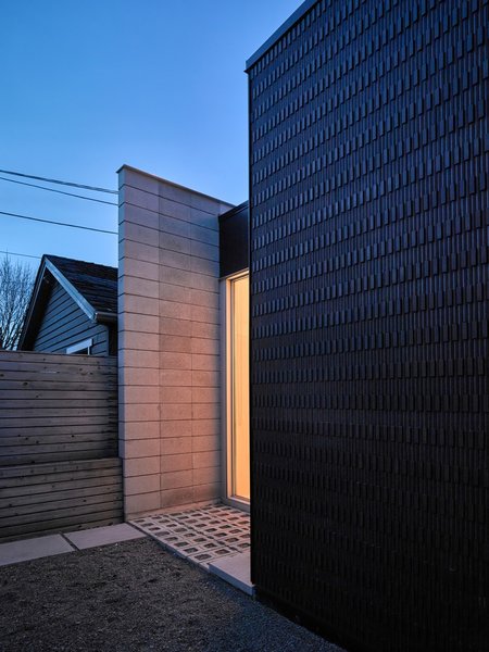 Concrete pavers line the outdoor entry space. The roof is Duro-Last mechanically fastened single-ply membrane.