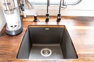 The kitchen features a Blanco Silgranit sink with a Lyty drinking water purifying faucet and a Hiendure built-in soap dispenser. The counter is made of walnut.