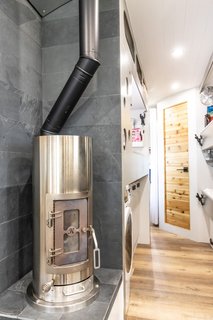 Surrounded by black slate panels, the stainless steel Kimberley wood stove provides extra warmth in addition to the propane heater.