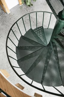 The spiral staircase and railings are finished in Dulux Classic Hawthorn Green Gloss to match the indoor plants, green curtains, and green pendant lighting.