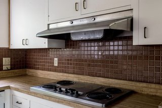 A look at the dated kitchen. <span style="font-family: Theinhardt, -apple-system, BlinkMacSystemFont, "Segoe UI", Roboto, Oxygen-Sans, Ubuntu, Cantarell, "Helvetica Neue", sans-serif;">All the pictured elements were swapped out</span><span style="font-family: Theinhardt, -apple-system, BlinkMacSystemFont, "Segoe UI", Roboto, Oxygen-Sans, Ubuntu, Cantarell, "Helvetica Neue", sans-serif;"> for new materials and appliances.</span>
