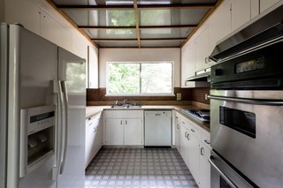 Despite the large window framing the outdoors, the existing U-shaped kitchen felt cramped compared to modern kitchens.