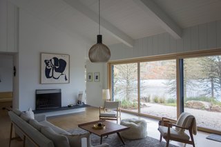 The minimalist fireplace was painted over and reduced in size, then articulated with cantilevered cleft slate hearths on either side. Seating is from the Design Within Reach Raleigh collection.