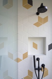 The kids' bathroom and entry bathroom sport colorful, geometric tile for a playful touch.