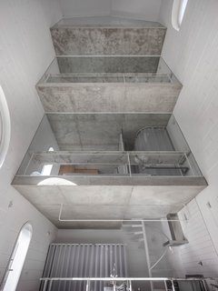 "The section and internal void works as a space where light travels around and produces a very calm sense of interiority. But also, from the rooms, it becomes a sort of interior courtyard," Zamarbide said. The unfinished concrete slabs contrast with the cement block walls painted white.