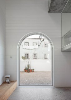 Fitted with glass, a massive arched pivot door, made by Much More than a Window, provides access to the outdoor patio.