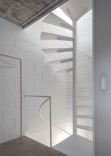 At the rear of the house is a minimalist spiral staircase that winds up all four floors.