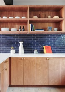 The updated kitchen features an Elite Tile backsplash selected by NMT Financial along with white quartz countertops, and new plumbing and lighting fixtures also selected by NMT Financial . These features were coordinated into the custom-millwork designed by See Arch and built by Greenport Designs.