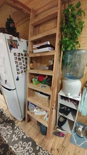 The bookcase ladder's long treads translate to extra storage space. The double-loft spaces above contain the sleeping areas.