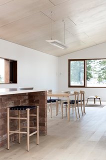 Tongue-and-groove Piccolo Eterno oak floorboards line the home. The dining room includes a vintage Alvar Aalto table paired with Lightwood Chairs by Jasper Morrison.