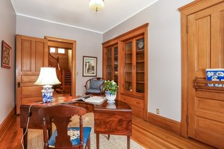 The den is accessible from the foyer and the family room and comes with built-in bookcases with glass doors and drawers.