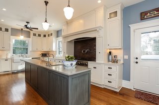 Remodeled in 2012, the expanded chef's kitchen is fitted with quartz countertops, state-of-the-art appliances, and an abundance of cabinet space. The high-end ceramic tile above the Wolf range mimics the Wright tile found in the fireplace surrounds.