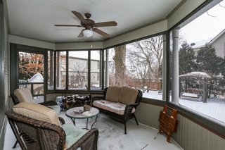 Shaped as a half octagon, the screened porch overlooks professionally landscaped lawns with brick paver walkways.