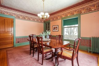 The dining room includes a built-in hutch with glass display doors and a lower cabinet, as well as a period light fixture.
