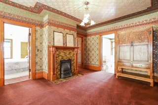 The second-floor landing is lined with carpet and comes with an original fireplace with tile surround and a wooden mantel.