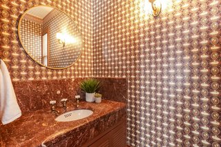 A peek inside the ground-floor powder room with a marble-top vanity and period faucet.