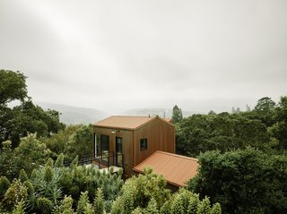 Surrounded by a sea of forest in Northern California, the Portola Valley House features fire-resistant construction. The annex is wrapped with Corten corrugated siding, while <i>shou sugi ban </i>treated timber clads the main house.