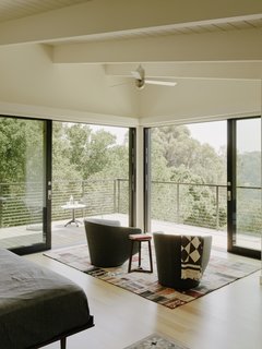 The view from the master bedroom. Sliding glazed pocket doors open up to the cantilevered deck. The U-Turn swivel chairs are by Niels Bendtsen from Design Within Reach.