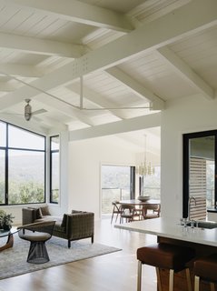 The architects preserved the existing beamed ceilings, which give the open-plan living area an airy feel. The living area is dressed with a vintage <i>tête-à-tête</i> sofa by Edward Wormley, a Warren Platner chair, and an Isamu Noguchi table.