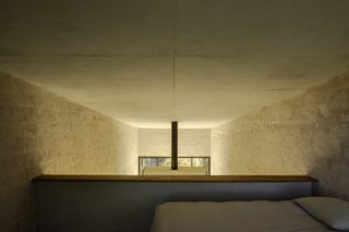 The loft bedroom is located beneath the highest point of the roof and overlooks the sitting area below.