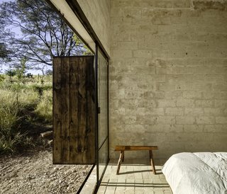 Sliding glazed doors open the ground-floor bedroom up to the outdoors. The timber bench was locally crafted.