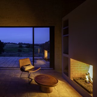 The wood-burning hearth fills the home with an orange glow at night.