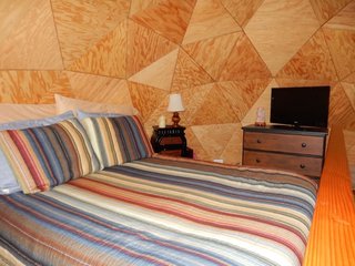 Underneath the "mushroom cap" geodesic dome is a loft bedroom with a queen-sized Casper mattress as well as a 32" flat-screen TV.