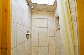 A peek inside the travertine shower, which is illuminated by a skylight.
