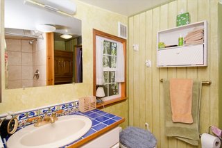 The custom-tiled sink adds a pop of color and personality to the compact bathroom. In the corner is a Nature's Head composting toilet.