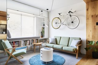 The fixed-gear bicycle hanging above the couch serves as an art piece; Chen no longer rides the bike. Le Corbusier Projecteur 165 pendant lights hang in the corner.