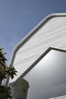 White Colorbond cladding wraps the new extension to maximize solar reflectance and reduce dependence on mechanical cooling.