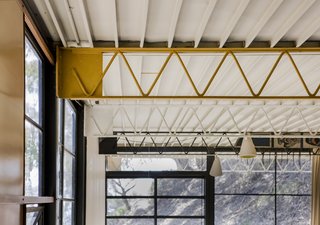 The exposed web joists were painted different colors, while the ribbed underside ceiling of the Ferrobord roof decking was painted white.