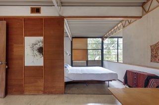 A view into the master bedroom as seen from the guest bedroom. When open, the sliding wood panel combines both bedrooms into one large space.
