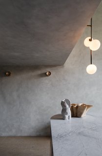 The Anton Mini wall sconces in the entrance hall are also by Volker Haug.