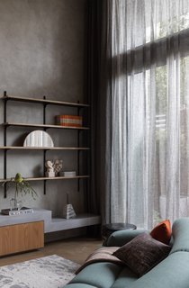 A full-height glazed wall allows natural light from the west to filter inside the apartment.