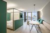 Modern home with Bedroom, Bed, Wardrobe, Pendant Lighting, and Medium Hardwood Floor. The nine spacious suites can sleep five to six people. Local larch is left unfinished to tie the interiors to the landscape. Photo 8 of Family Resort Rainer